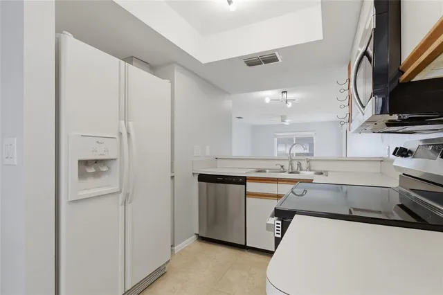 a kitchen with appliances a sink and cabinets
