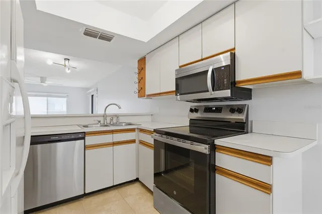a kitchen with cabinets stainless steel appliances and a sink