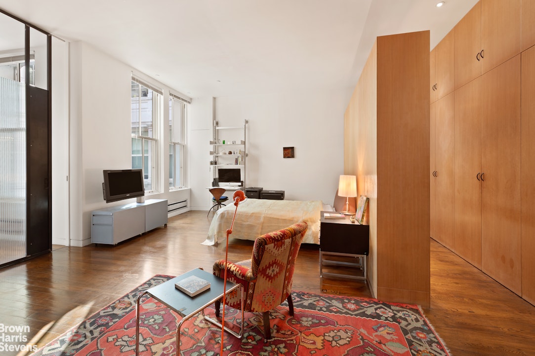 110 Mercer Street, Unit 4 Manhattan, NY 10012 - Photo 6 of 8 a living room with furniture and a wooden floor