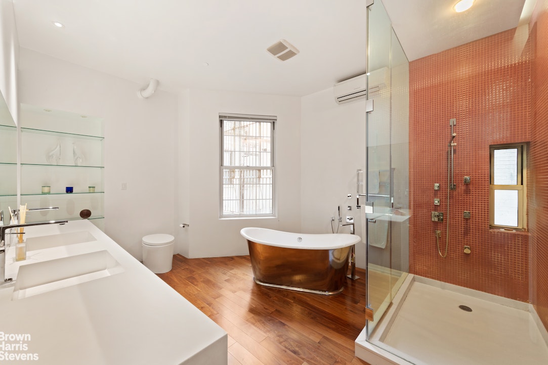 110 Mercer Street, Unit 4 Manhattan, NY 10012 - Photo 7 of 8 a spacious bathroom with a tub sink and mirror