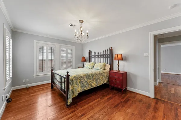 a bedroom with a bed wooden floor and window