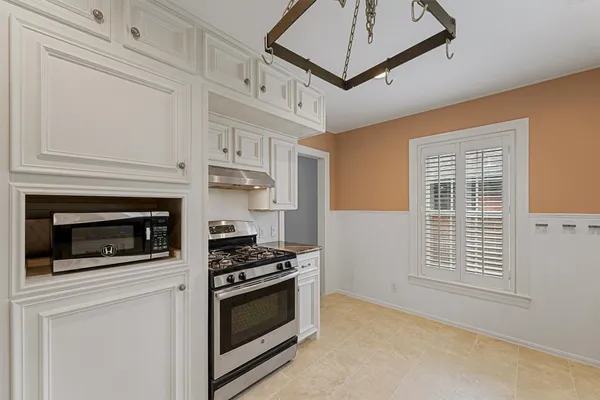 a kitchen with stainless steel appliances white cabinets and a stove