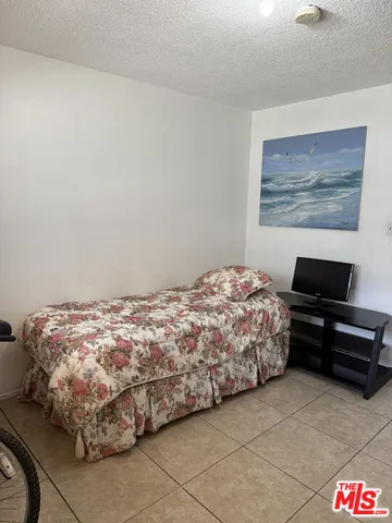 a bedroom with a bed and a wall painting