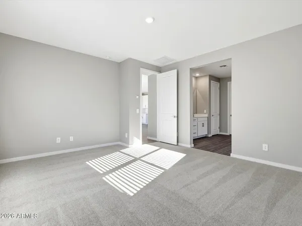 an empty room with ceiling fan and windows