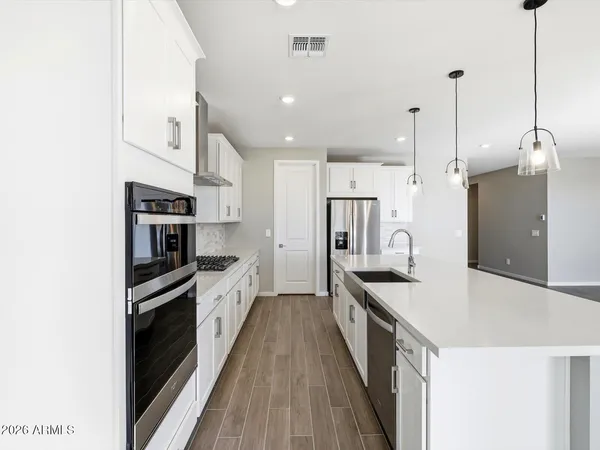 a large kitchen with stainless steel appliances a refrigerator and a stove top oven