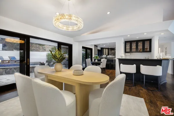 a dining room with furniture a kitchen view and a chandelier