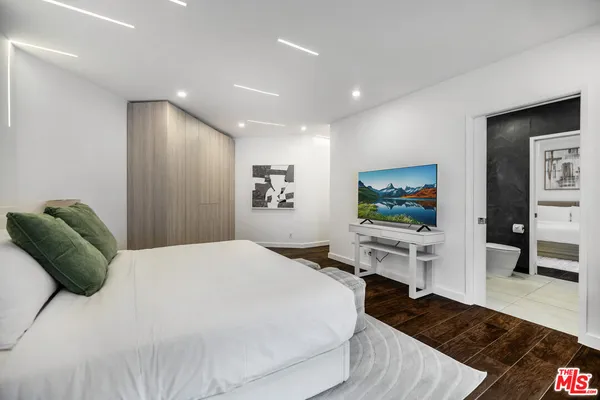 a bedroom with a bed and a flat screen tv