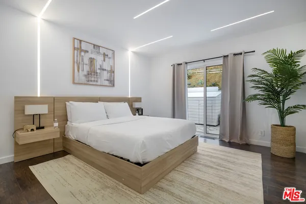 a bedroom with a large bed and a potted plant