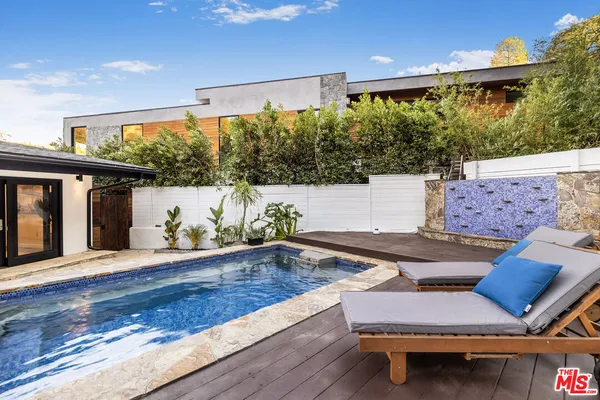 a swimming pool with outdoor seating and yard