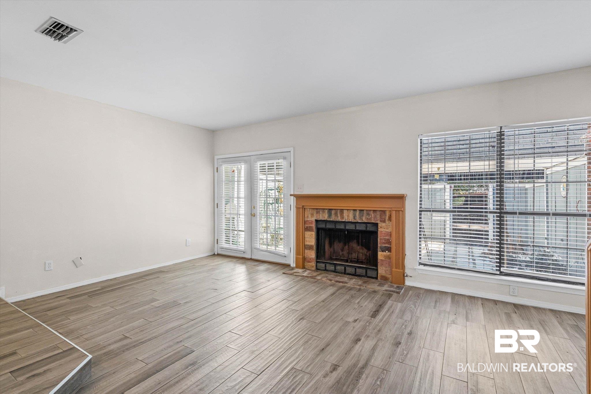 5900 Grelot Road, Unit 504 Mobile, AL 36609 - Photo 2 of 24 Unfurnished living room with a fireplace and light wood-style flooring