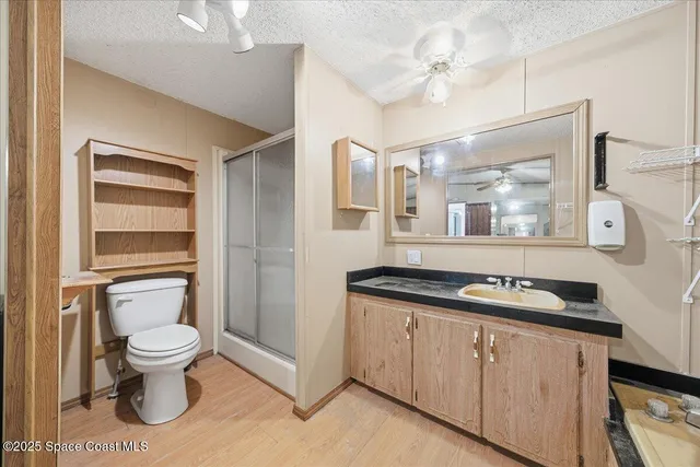 a bathroom with a granite countertop toilet sink and mirror
