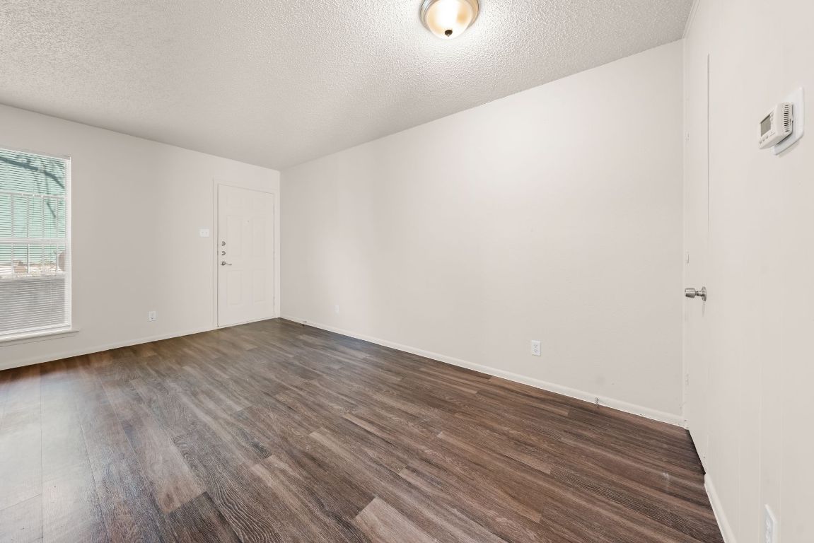 2314 Parker Lane, Unit 5 Austin, TX 78741 - Photo 13 of 17 a view of an empty room with wooden floor and a window