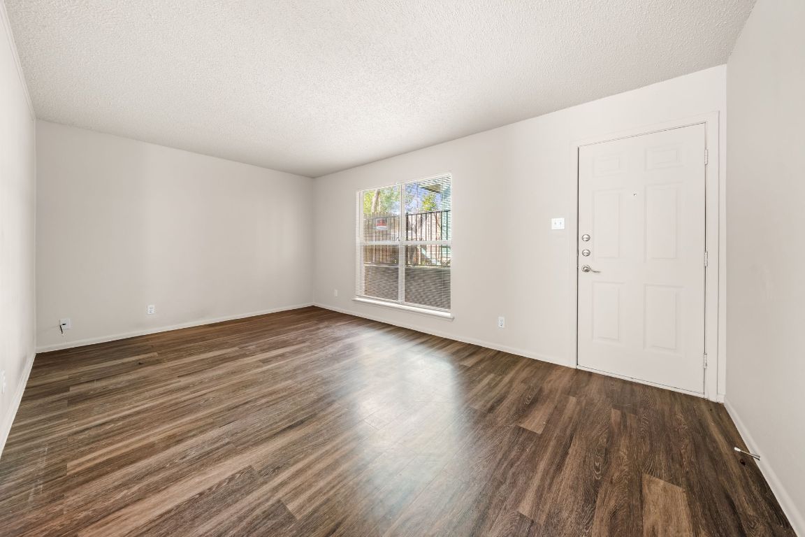 2314 Parker Lane, Unit 5 Austin, TX 78741 - Photo 4 of 17 a view of an empty room with wooden floor and a window