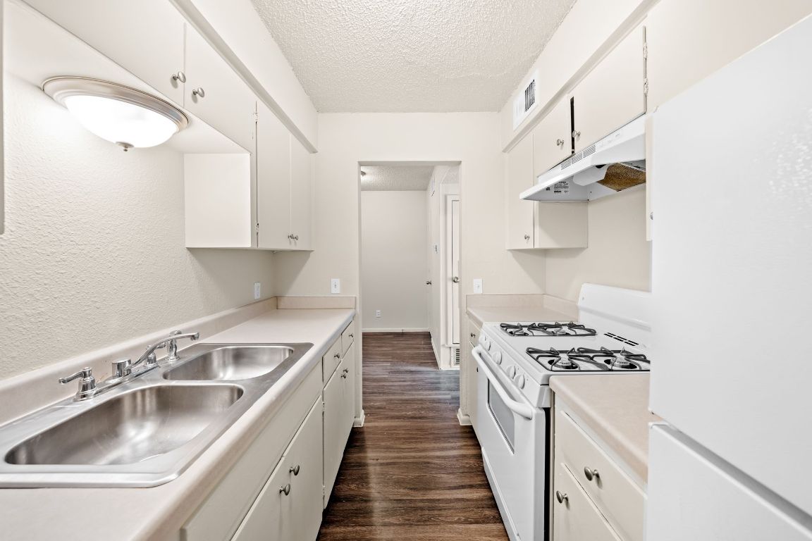 2314 Parker Lane, Unit 5 Austin, TX 78741 - Photo 6 of 17 a kitchen with white cabinets sink and stove