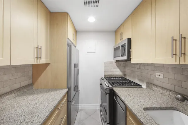 a kitchen that has a sink a stove and a oven