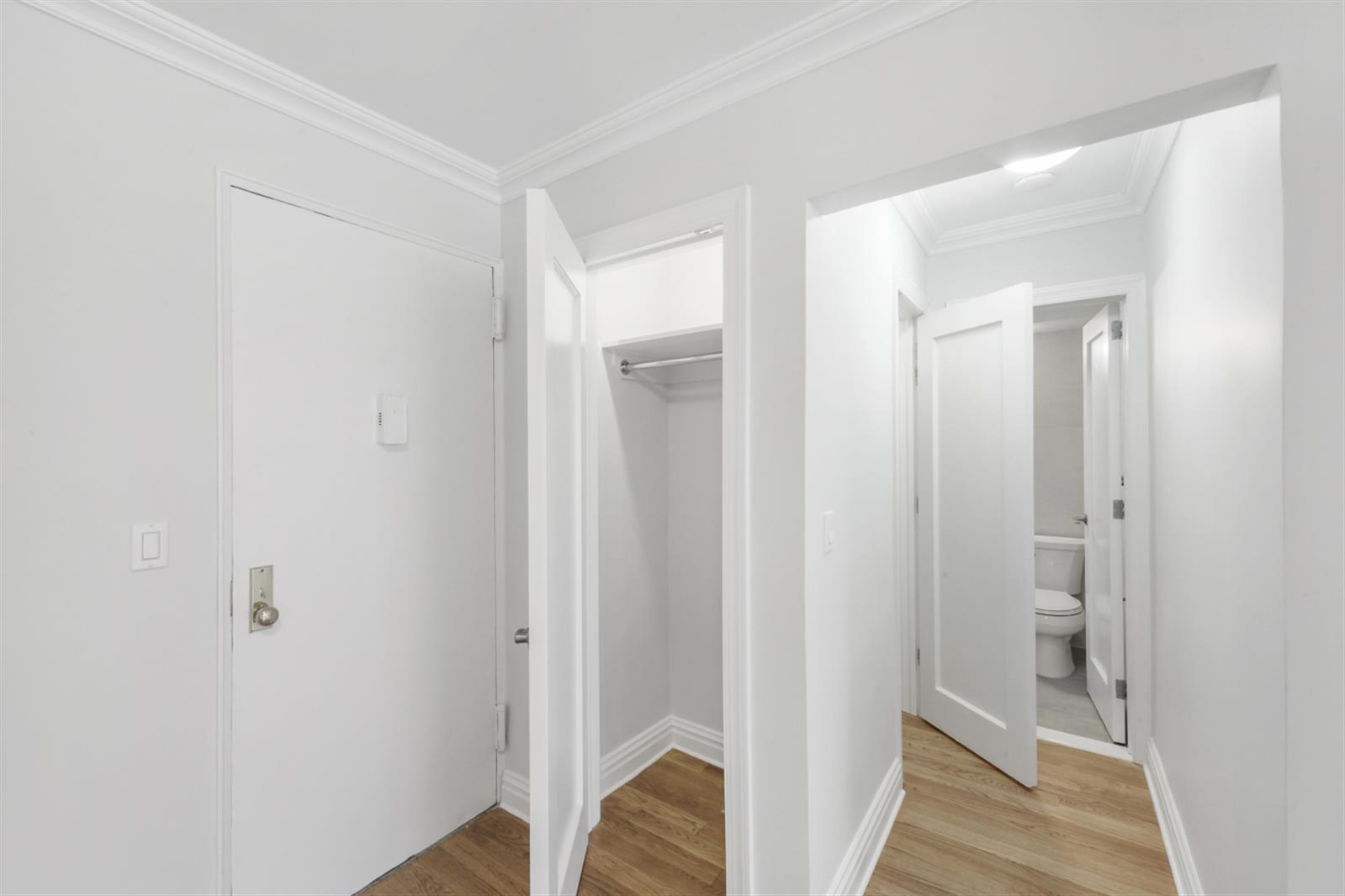 141 East 33rd Street, Unit 15H Manhattan, NY 10016 - Photo 7 of 9 a view of a hallway with wooden floor and closet