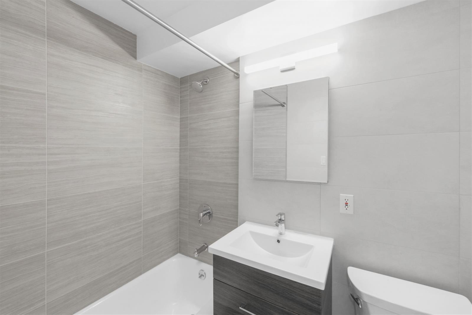 141 East 33rd Street, Unit 15H Manhattan, NY 10016 - Photo 8 of 9 a bathroom with a sink a toilet and shower