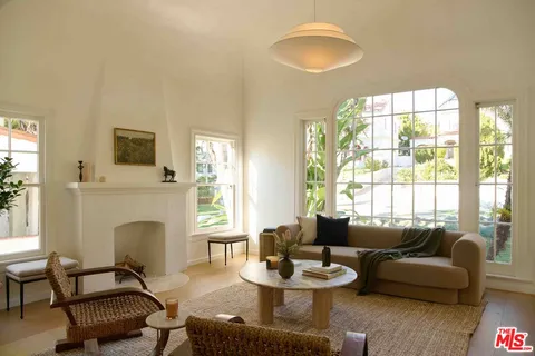 a living room with furniture a fireplace and a large window