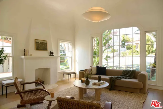 a living room with furniture a fireplace and a large window