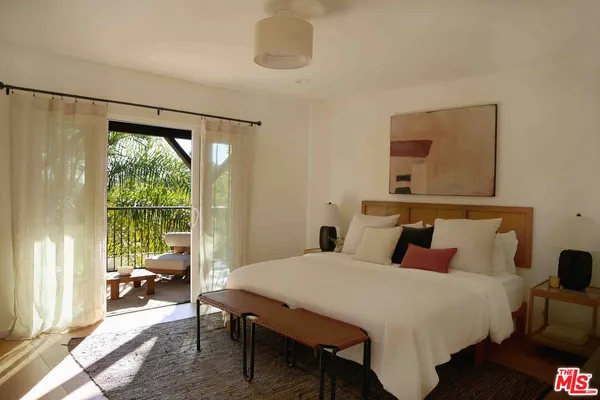 a bedroom with a bed and a large window