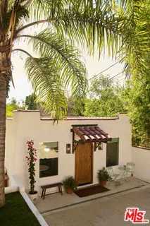 a kitchen with stainless steel appliances granite countertop a stove a refrigerator a sink a dining table and chairs with wooden floor