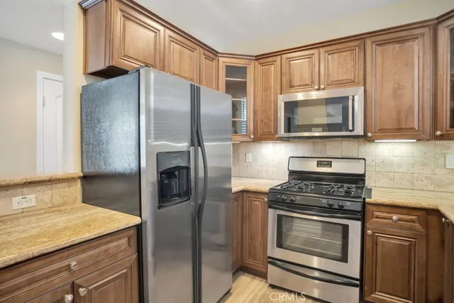 a kitchen with granite countertop a sink cabinets and stainless steel appliances