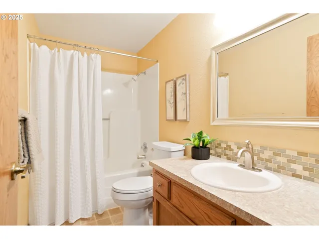 a bathroom with a granite countertop sink a toilet and a mirror