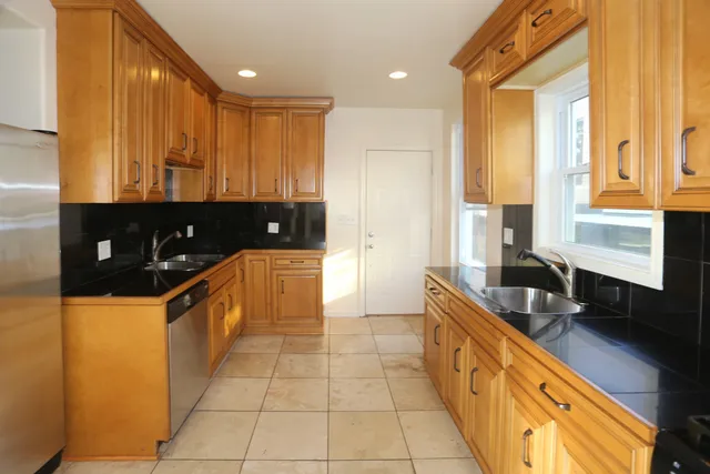 a kitchen with stainless steel appliances granite countertop a sink a stove and a refrigerator