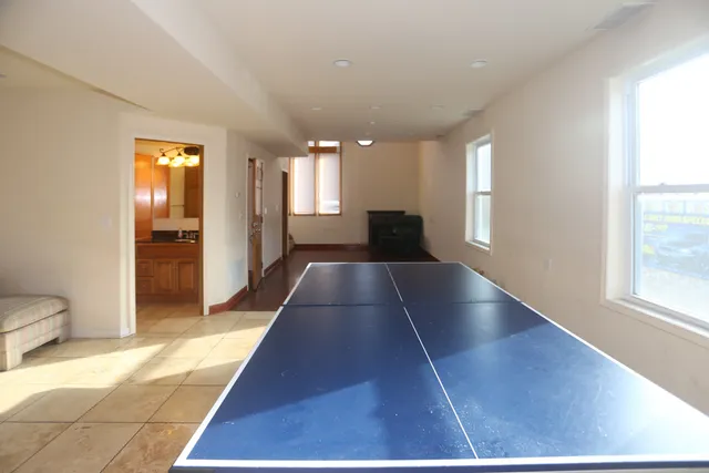 a view of a hallway with wooden floor and a living room