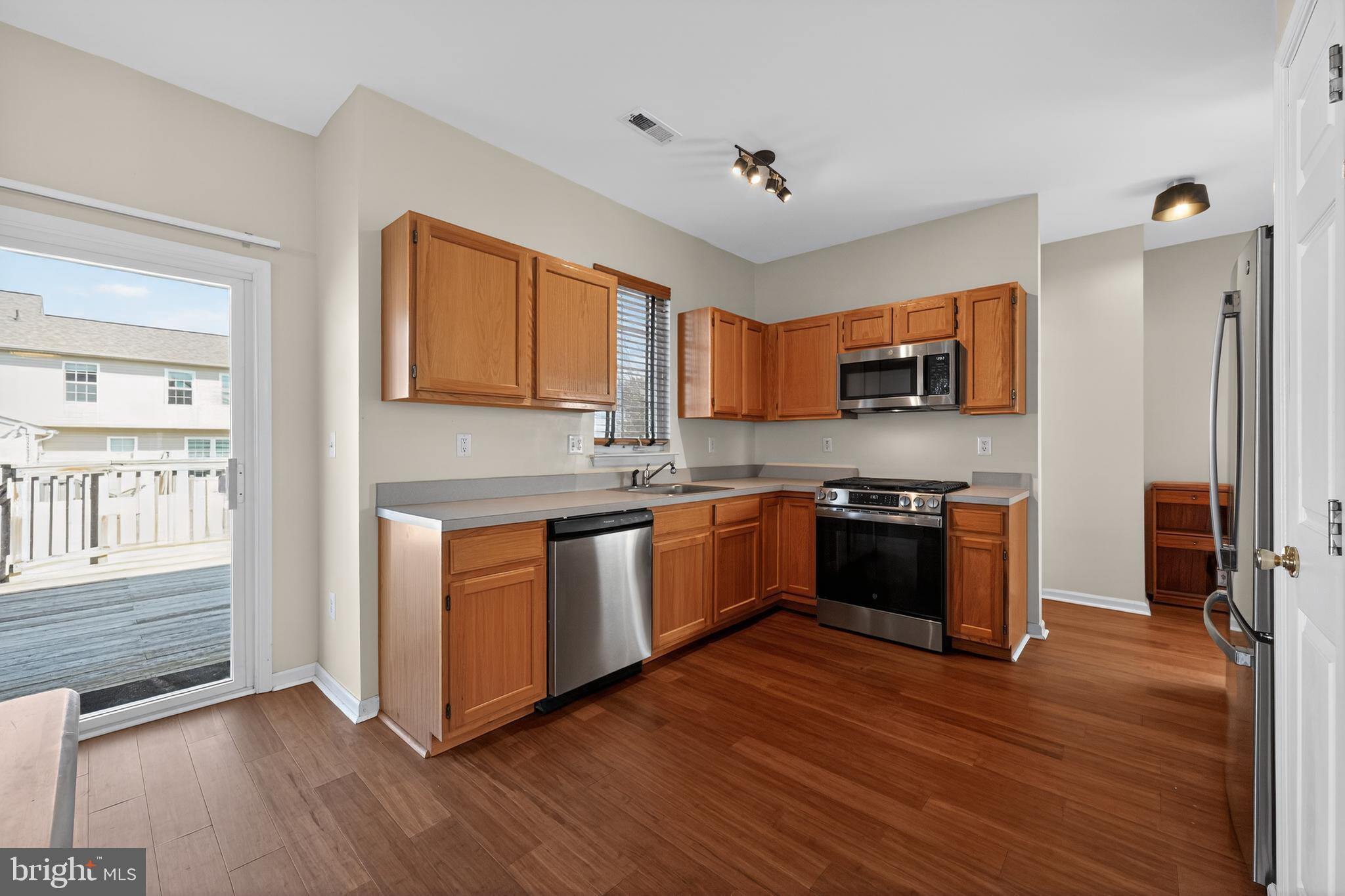 20 Colts Gait Road Marlton, NJ 08053 - Photo 8 of 36 a kitchen with stainless steel appliances granite countertop a stove top oven a sink dishwasher and a refrigerator with wooden floor