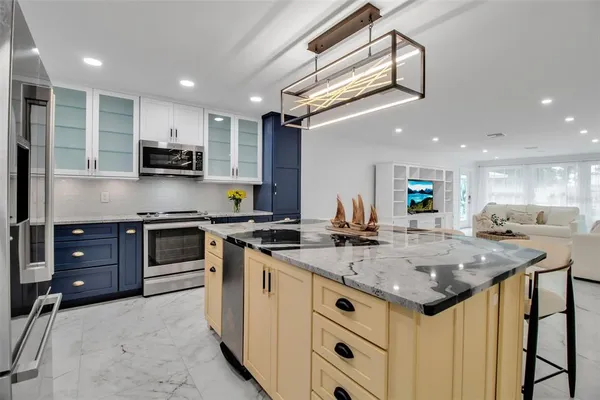 a kitchen with stainless steel appliances kitchen island granite countertop a stove and a sink
