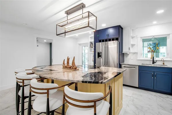 a kitchen with stainless steel appliances granite countertop a dining table and chairs