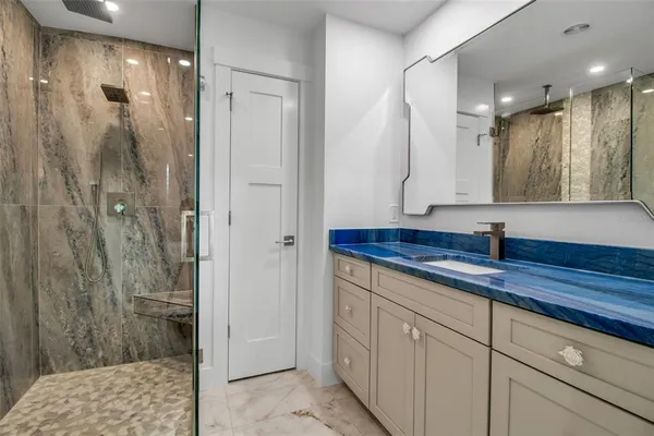 a bathroom with a shower sink and mirror