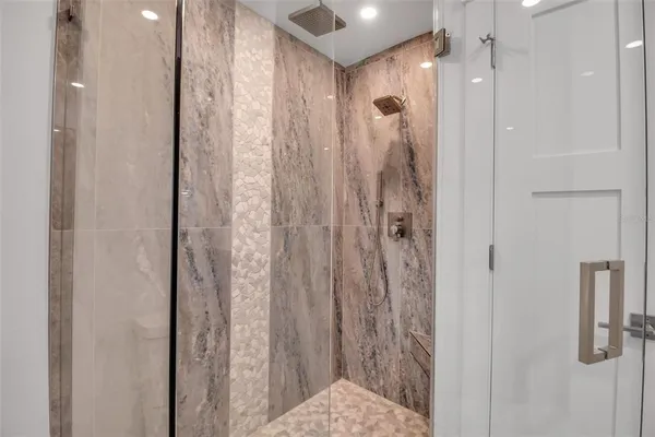 a bathroom with a shower and a glass door
