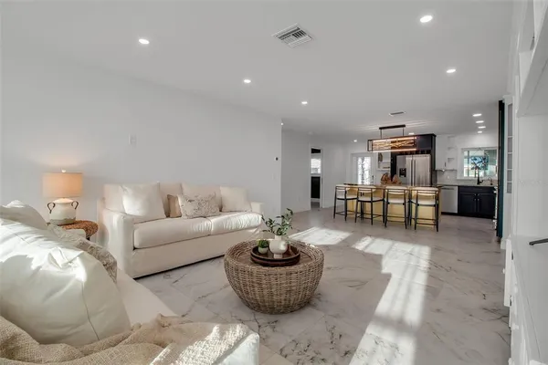 a living room with furniture and a view of kitchen