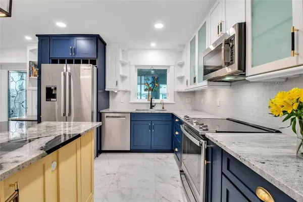 a kitchen with stainless steel appliances granite countertop a sink stove and refrigerator