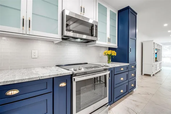 a kitchen with stainless steel appliances granite countertop a stove and a microwave