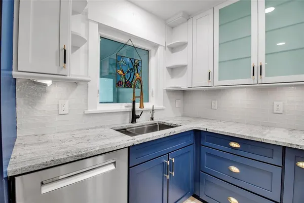 a kitchen with granite countertop a sink and cabinets