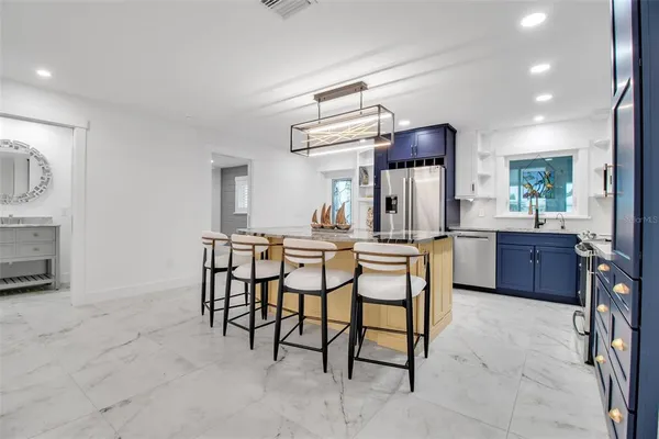 a room with stainless steel appliances a dining table and chairs
