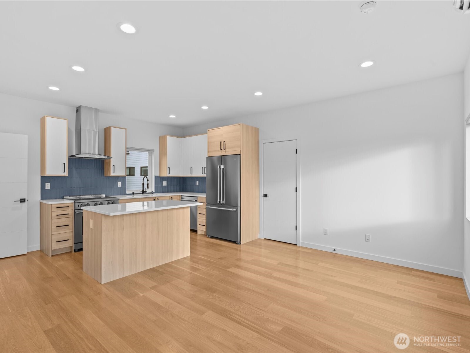 3239 61st Avenue Southwest, Unit B Seattle, WA 98116 - Photo 8 of 30 a large kitchen with cabinets wooden floor and stainless steel appliances