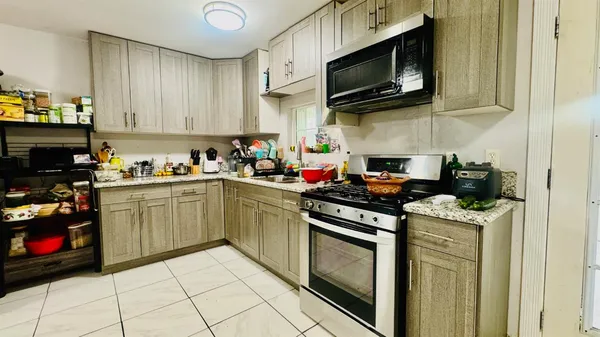 a kitchen with stainless steel appliances a stove top oven a sink a counter space and cabinets