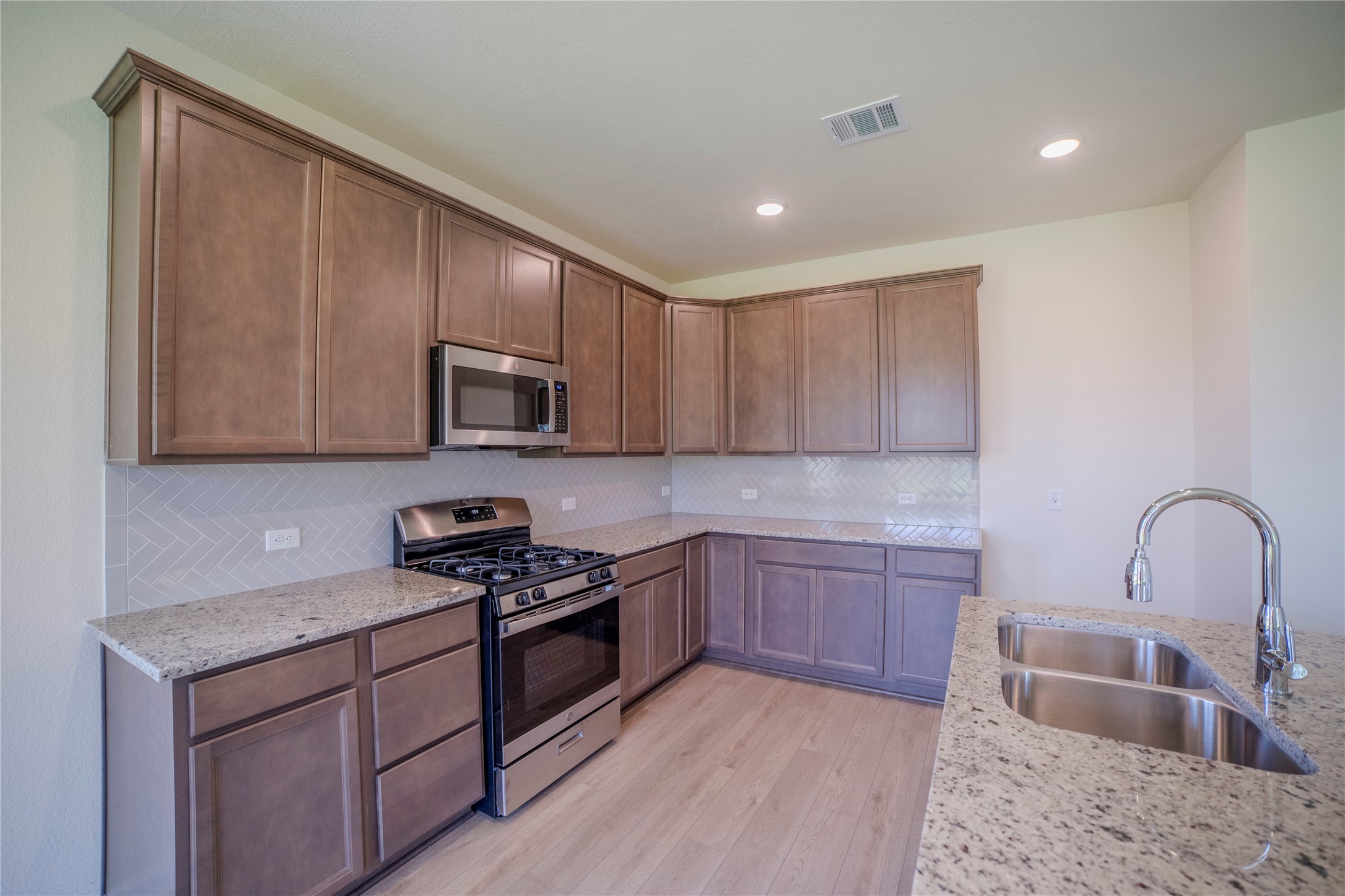 1402 Lk Rdg Drive Brenham, TX 77833 - Photo 22 of 35 a kitchen with stainless steel appliances granite countertop a stove a sink and a microwave