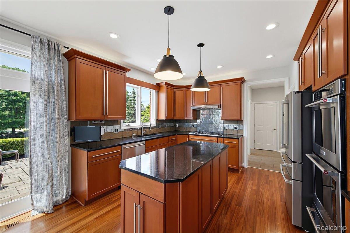 1422 Galena Rochester, MI 48306 - Photo 21 of 73 Kitchen featuring cherry wood cabinetry, black granite countertops, stainless steel appliances, and wood-finish flooring