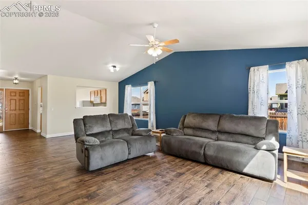 a living room with furniture and a wooden floor