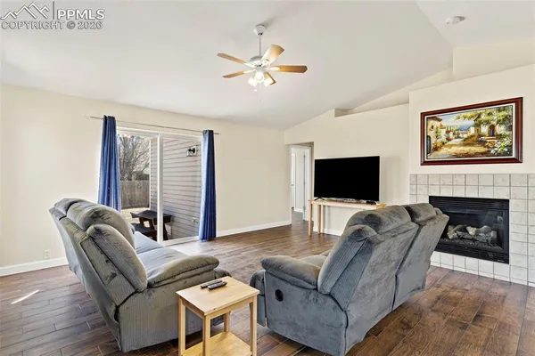 a living room with furniture a fireplace and a flat screen tv