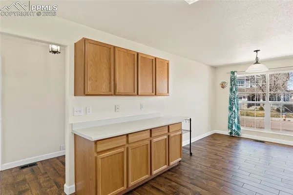 a hallway with wooden floor and cabinet