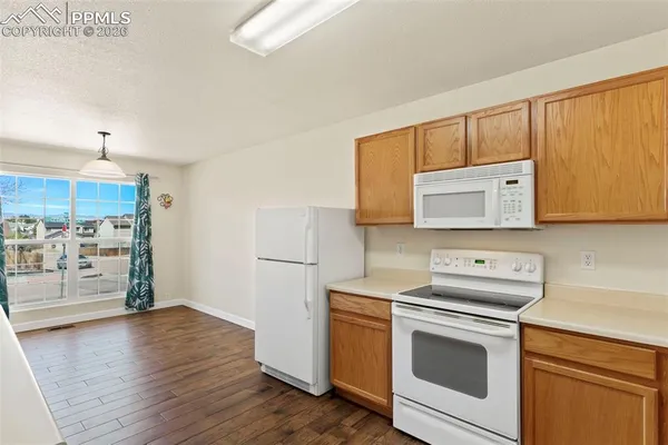 a kitchen with stainless steel appliances white cabinets and a wooden floor