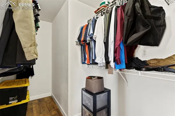 a view of walk in closet with clothes and shoes