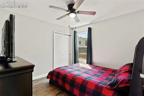 a bedroom with a bed and a flat tv screen on the dresser