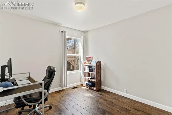 a view of a workspace with furniture and wooden floor